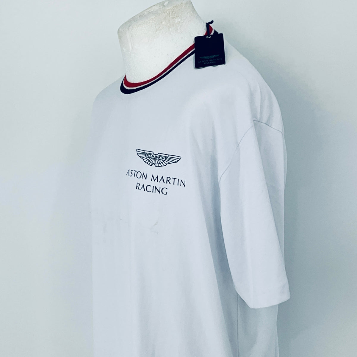 White shirt with Aston Martin Racing logo on a mannequin against a white background