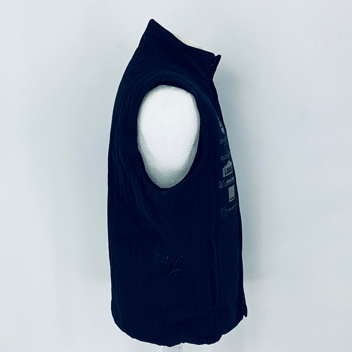 Black sleeveless jacket on a mannequin against a white background