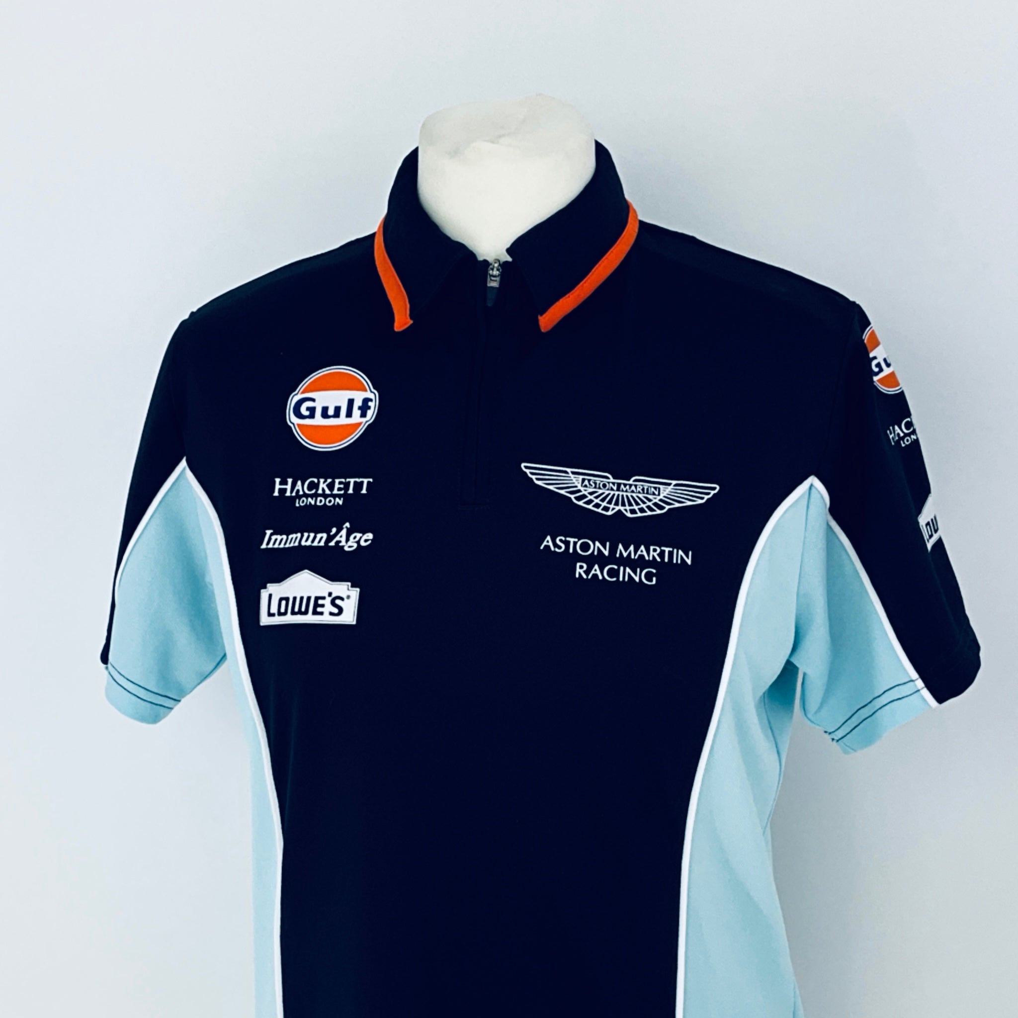 Navy and light blue racing shirt with various sponsor logos on a mannequin against a white background