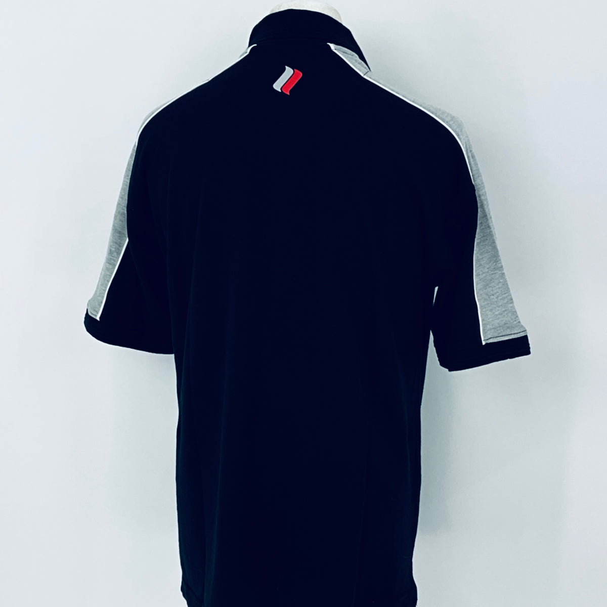 Black polo shirt with gray sleeves on a white background
