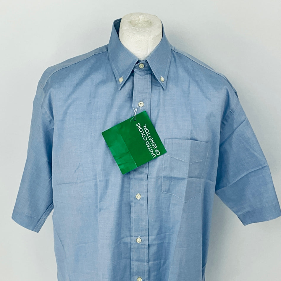 Blue shirt on a mannequin with a green tag against a white background