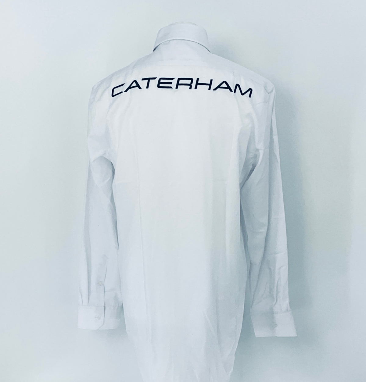 White shirt with 'Caterham' logo on the back against a white background