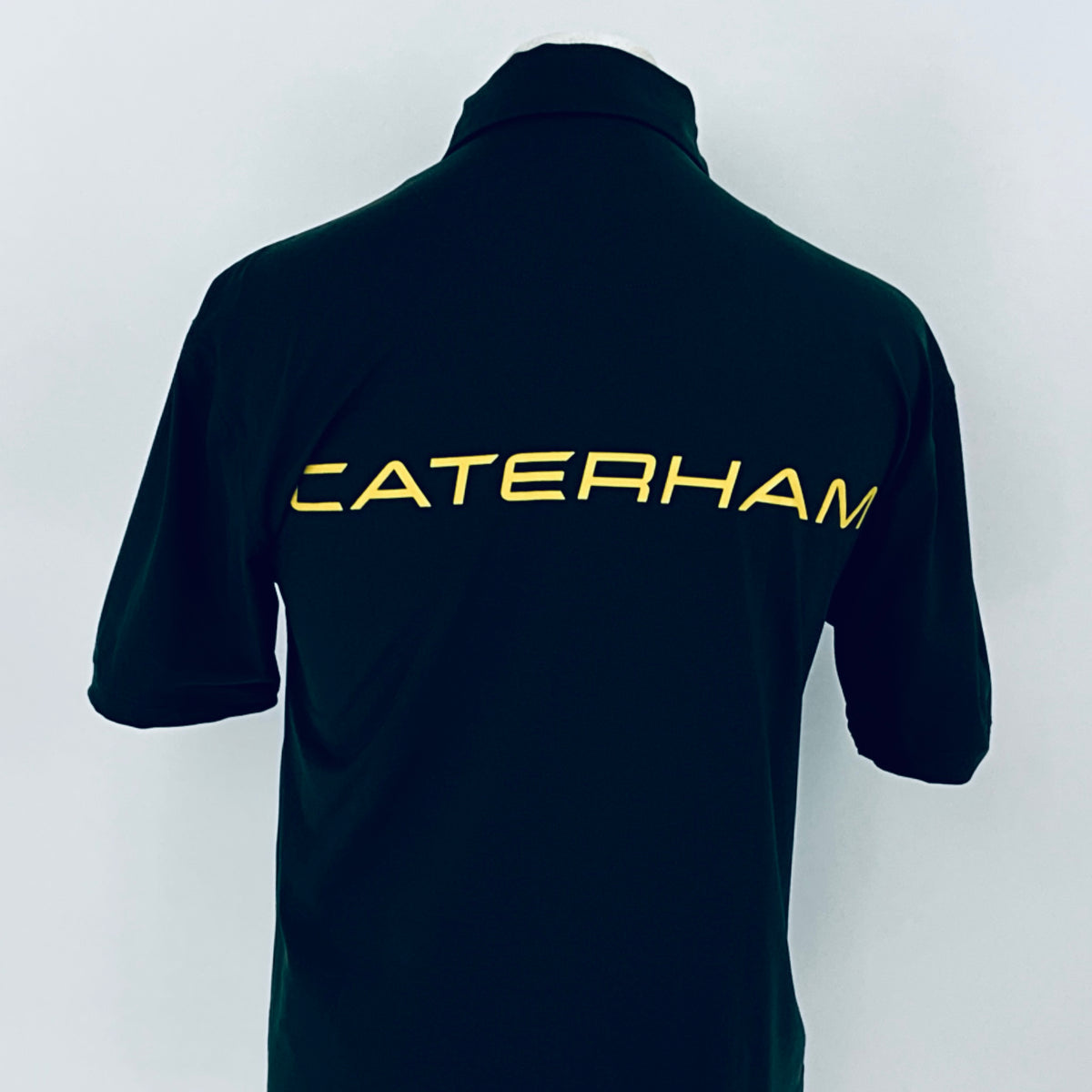 Black polo shirt with 'Caterham' logo on the back against a white background