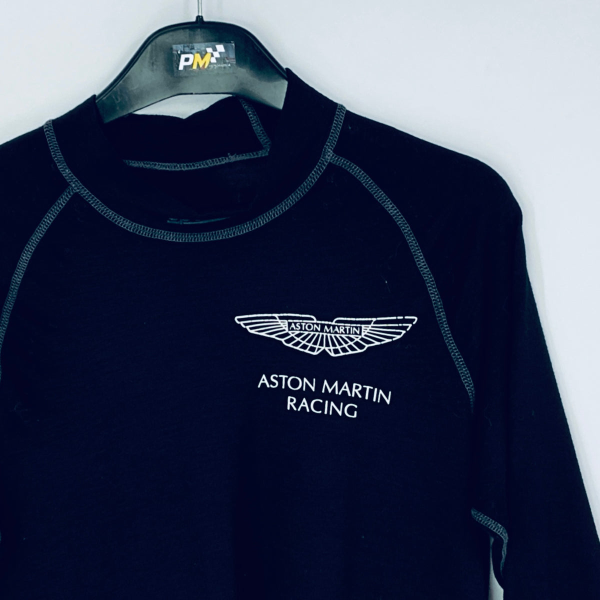 Black Aston Martin Racing sweatshirt on a hanger against a white background