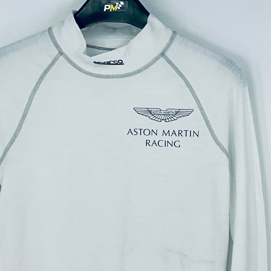 Gray long-sleeve shirt with Aston Martin Racing logo on a hanger.