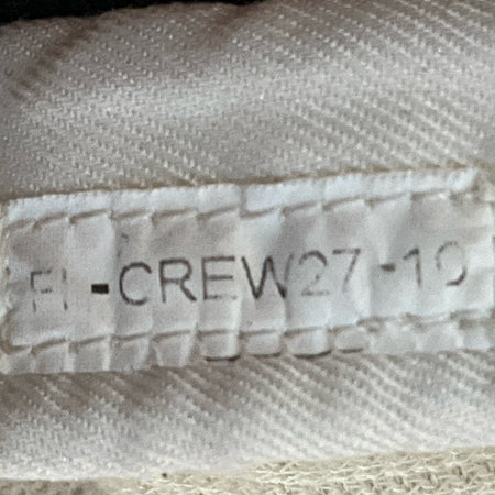 White pit crew suit fabric close-up with printed "F1 -CREW27-17" and stitching