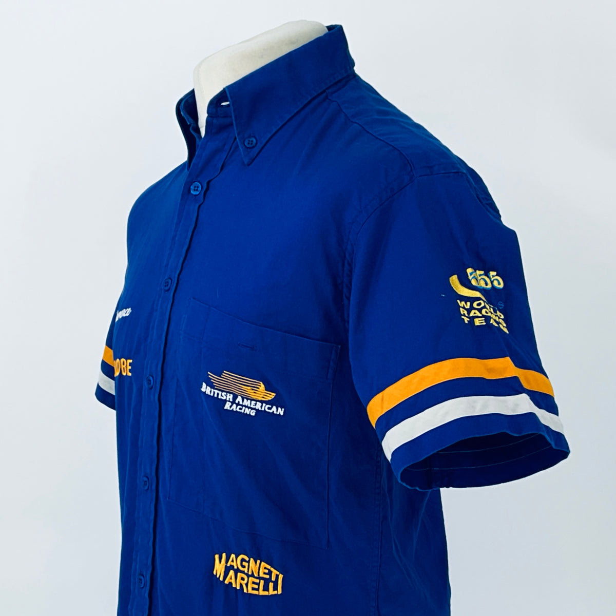 Blue short-sleeve button-up racing shirt side view with chest and sleeve logo patches