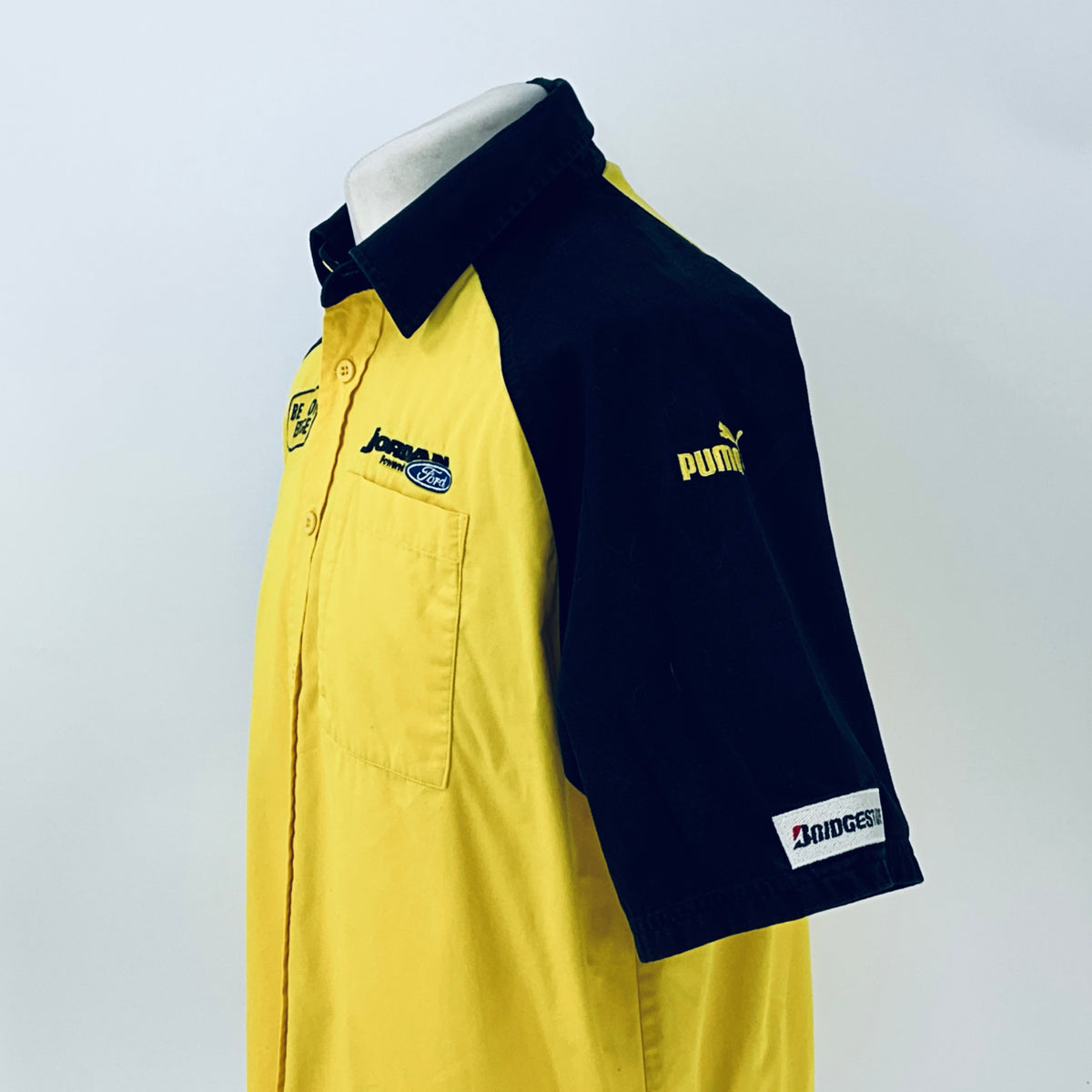Two-tone short-sleeve button-up shirt, side view showing yellow front and navy sleeve