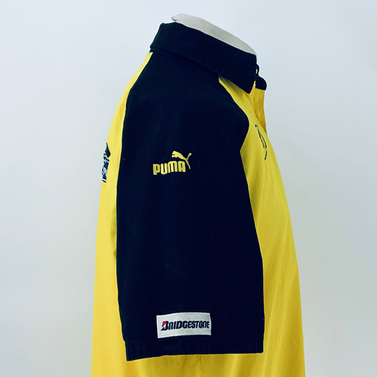 Two-tone short-sleeve button-up shirt, side view showing Puma logo on navy sleeve