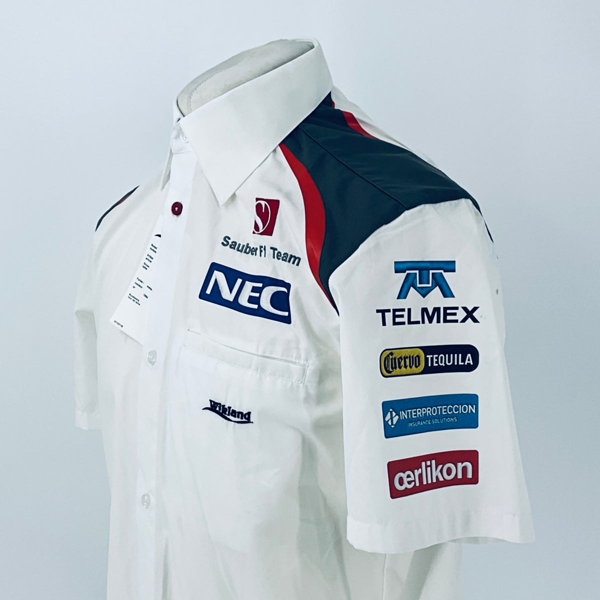 White racing shirt with button-up collar and TELMEX sponsor patch on sleeve