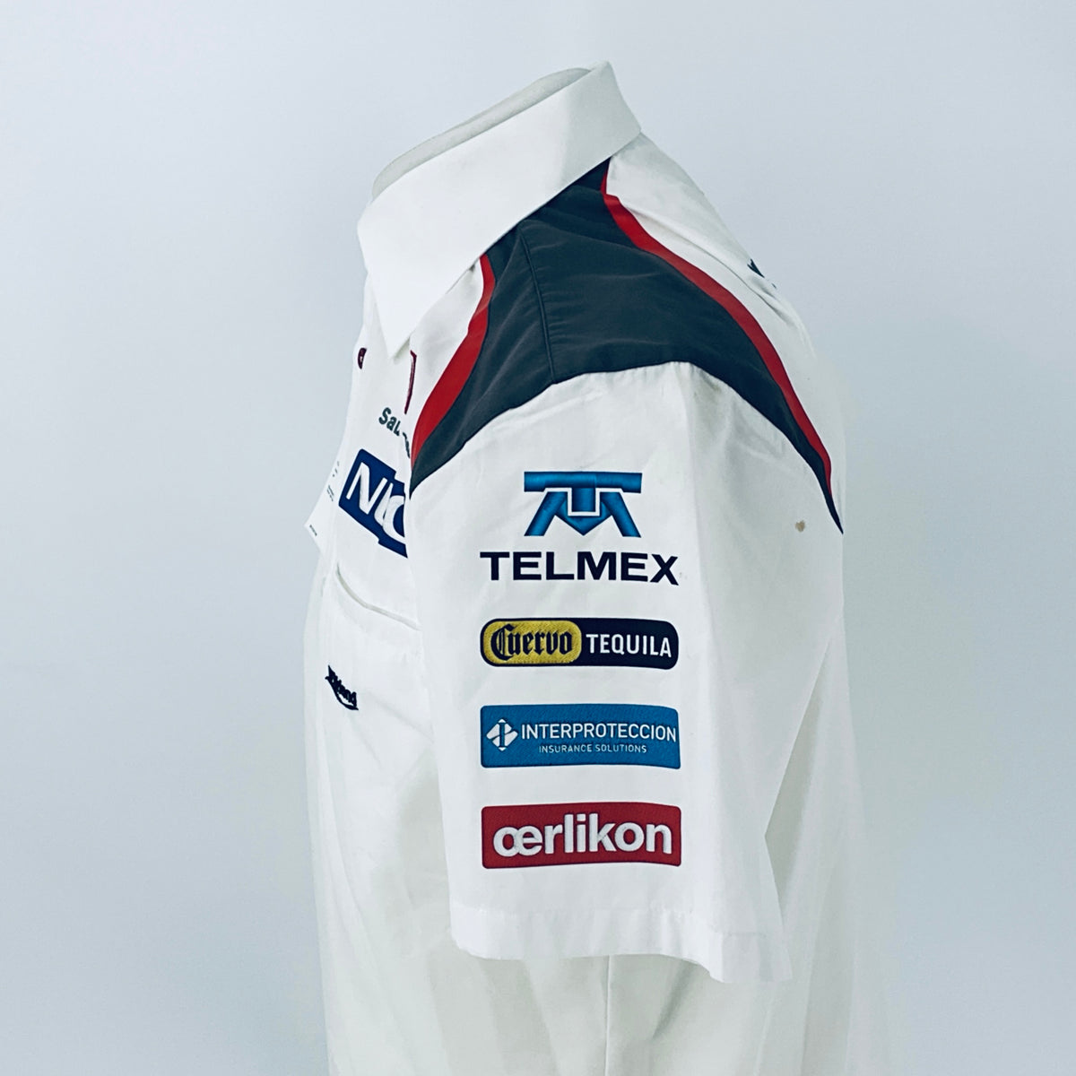 White racing shirt sleeve with TELMEX and Tequila sponsor patches