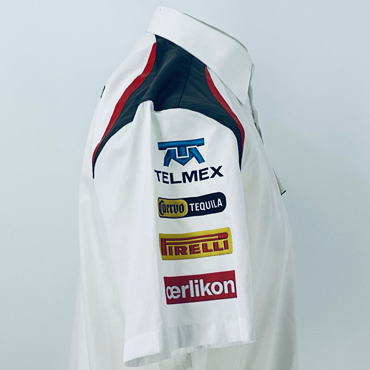 White racing shirt side view with TELMEX and Pirelli sponsor patches