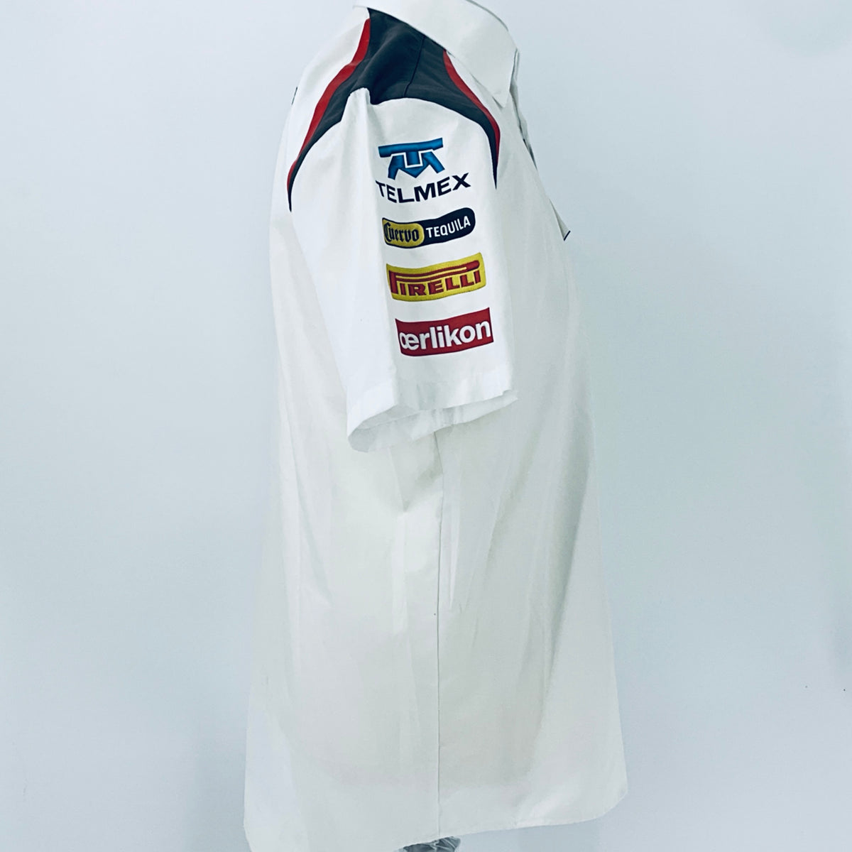 White racing team shirt with sleeve sponsor logos and red-blue shoulder panels