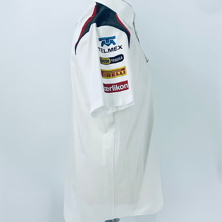 White racing team shirt with sleeve sponsor logos and red-blue shoulder panels