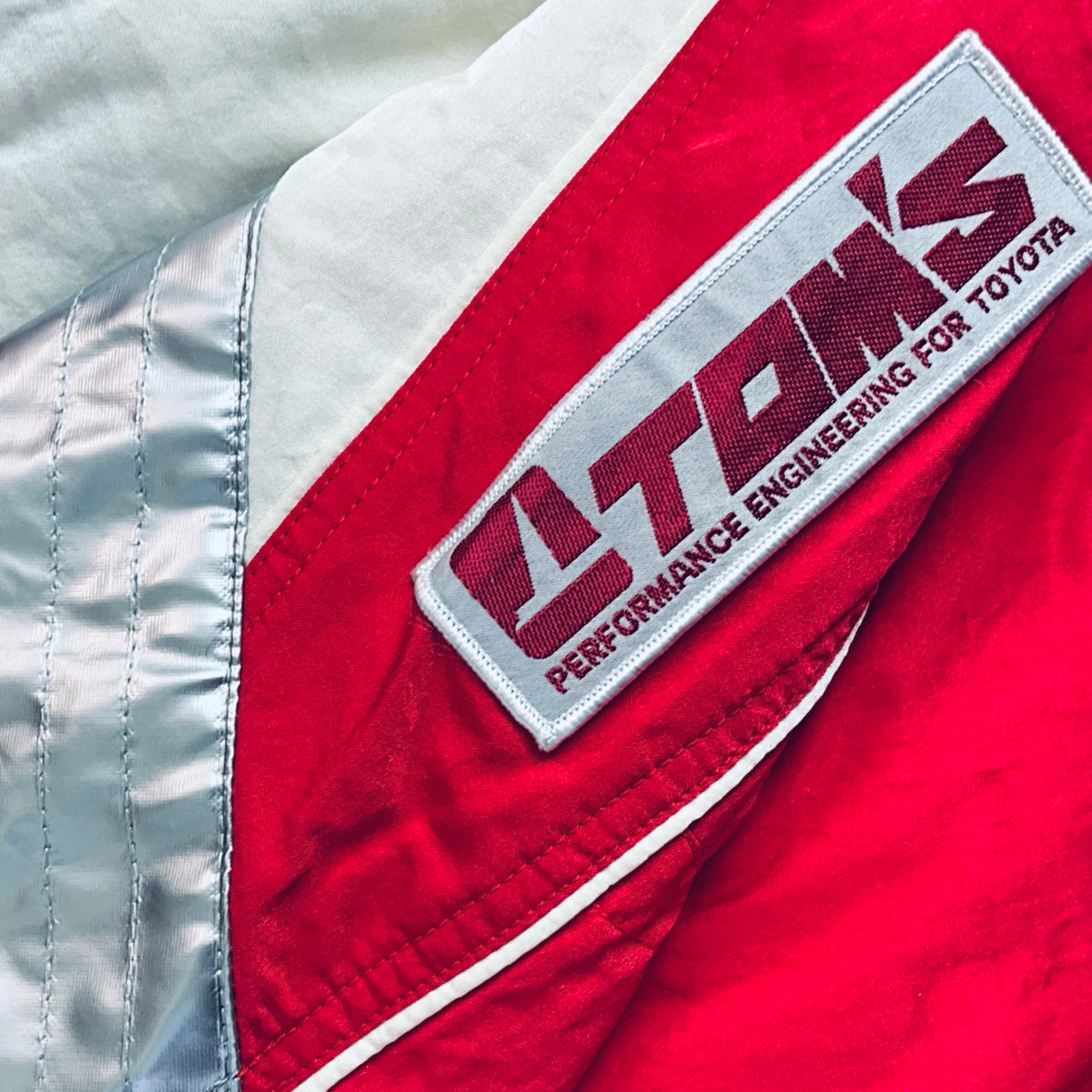 Performance engineering strap patch on red-and-white winter jacket sleeve