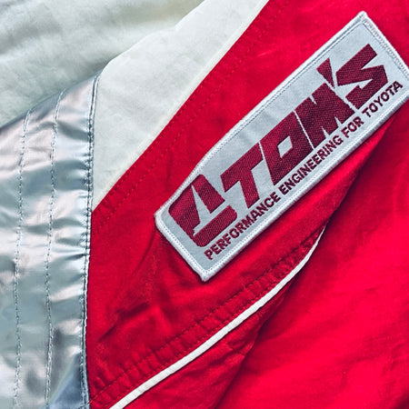 Performance engineering strap patch on red-and-white winter jacket sleeve