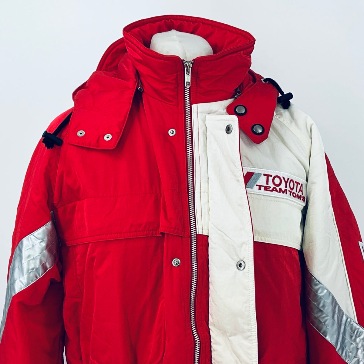 Red and white hooded parka with full-length zipper, button pockets, and Toyota patch