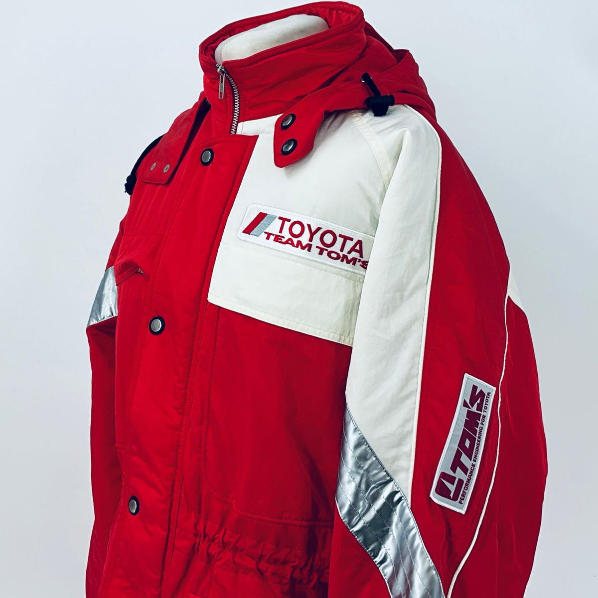 Red and off-white winter parka jacket with hood, Team TOM'S logo patch, and sleeve print