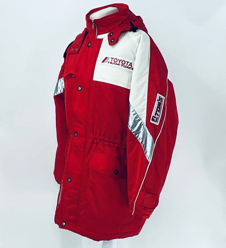 Red winter parka jacket with hood, Team TOM'S logo patch, and silver-gray diagonal sleeve panels