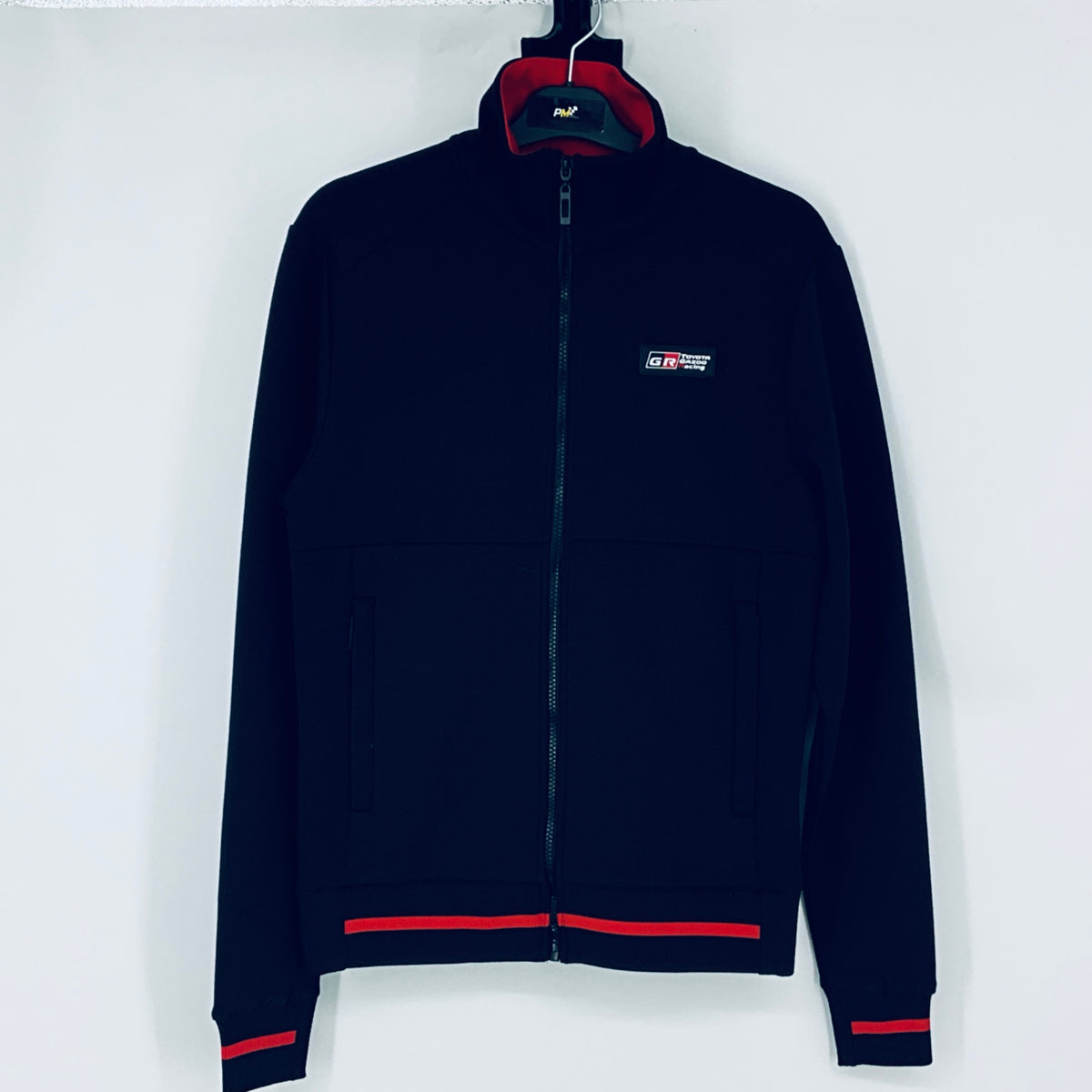 Dark navy full-zip sweatshirt, red-lined hood, chest logo, red cuff and hem stripes