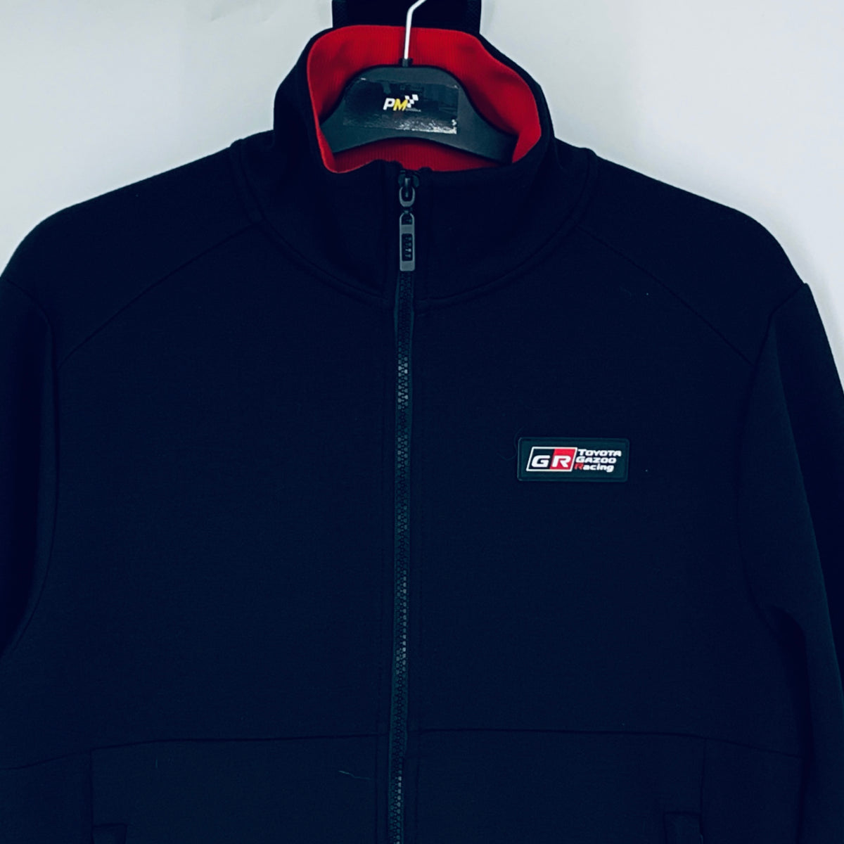 Dark navy full-zip sweatshirt with red-lined hood and GR logo badge on chest