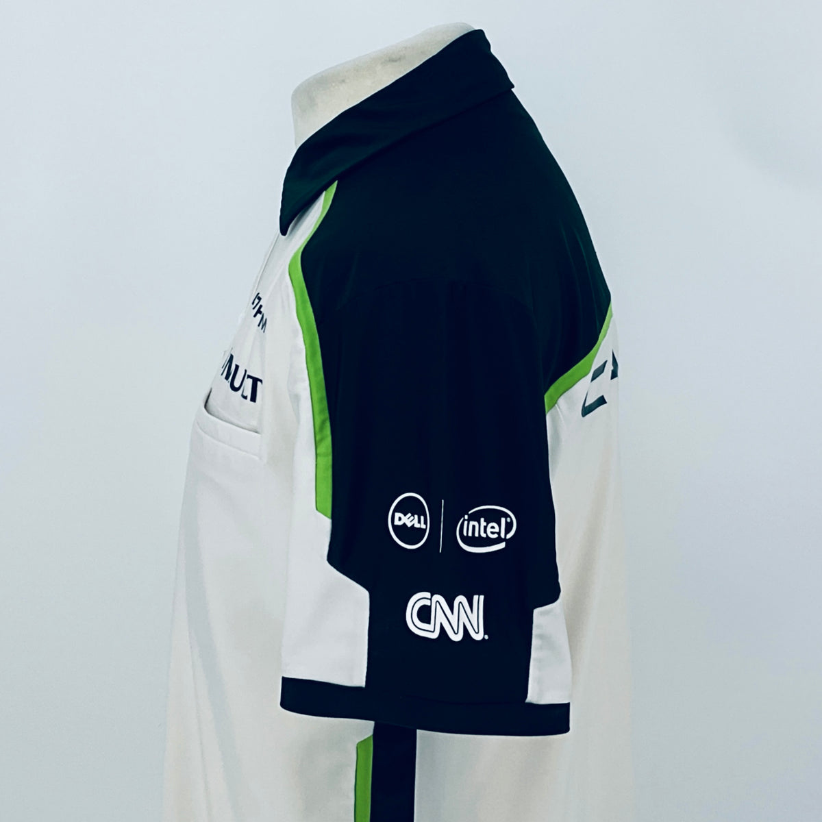 Team polo shirt sleeve detail: navy arm with white logos and green trim accents