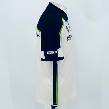 Team polo shirt profile view: navy sleeve with logo patch and white side panels