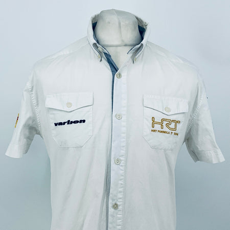White pit crew shirt, short sleeves, front button placket, and two chest logo patches.