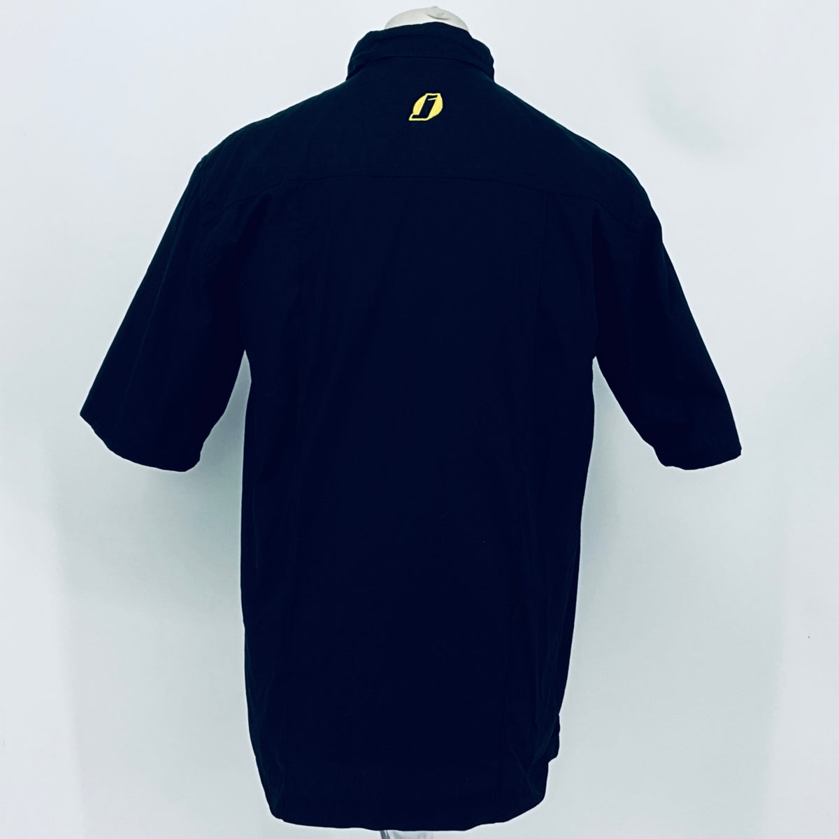 Dark navy short-sleeve button-up shirt, back view; small yellow emblem at upper back.