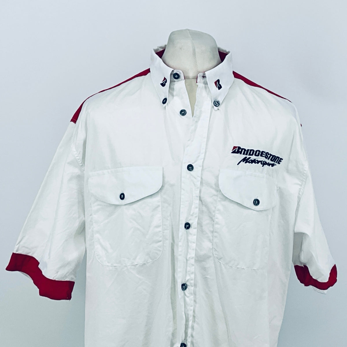 White button-up shirt with maroon shoulder stripes, chest pockets, and Bridgestone Motorsport logo.