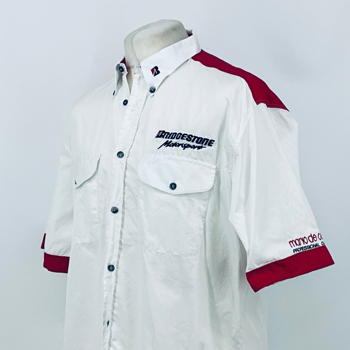 White button-up shirt with maroon sleeve panel, chest patch logo, and button front.