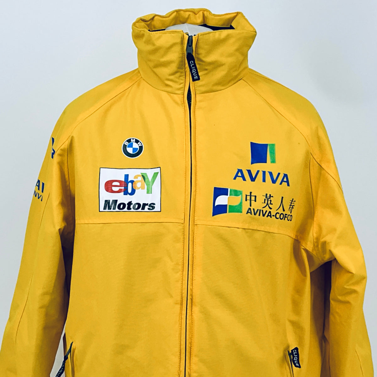 Yellow racing jacket with front zipper; Aviva, BMW logo, and sponsor patches on chest.