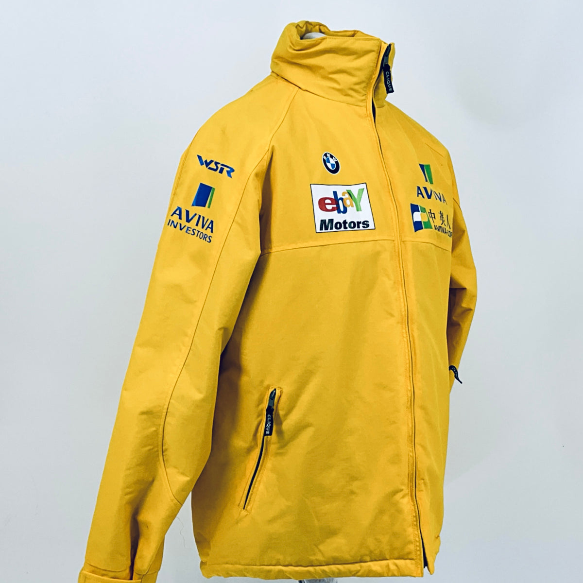 Yellow racing team jacket with hood, zip front, and logo patches