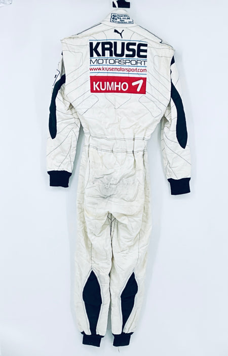 Race-worn driver suit back view: large “KRUSE” and “KUMHO 7” sponsor decals.