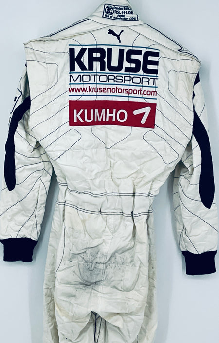 Race-worn driver suit back detail with “KRUSE Motorsports” text and “KUMHO 7” label.
