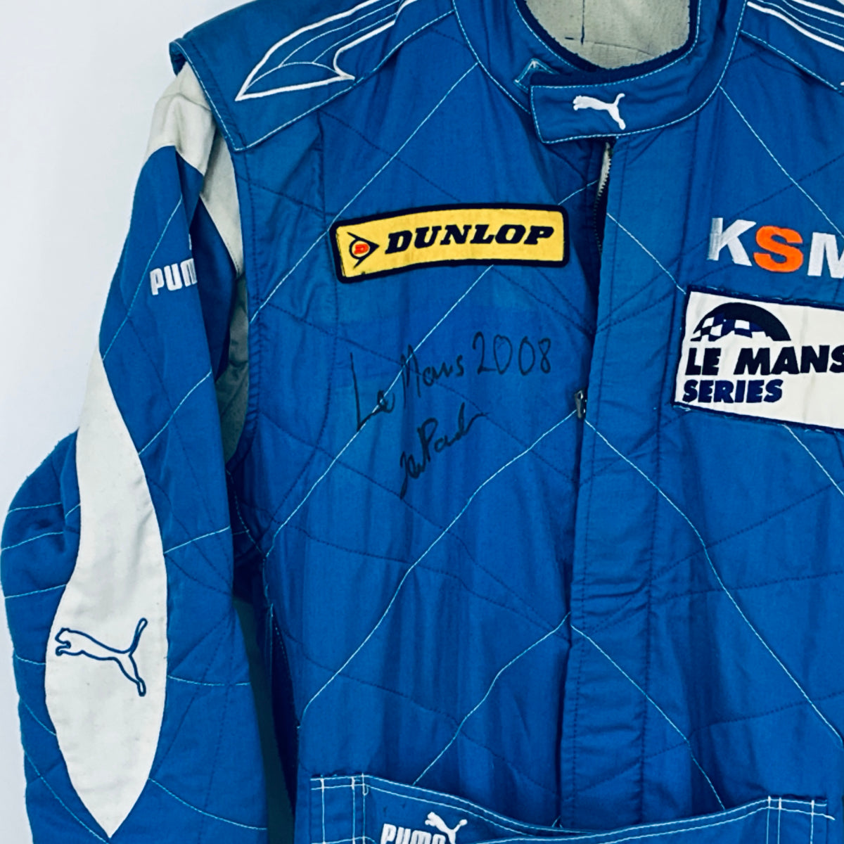 Blue driver suit front with DUNLOP patch, KSM and Le Mans Series logos, autograph