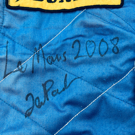 Handwritten autograph on blue quilted driver suit panel