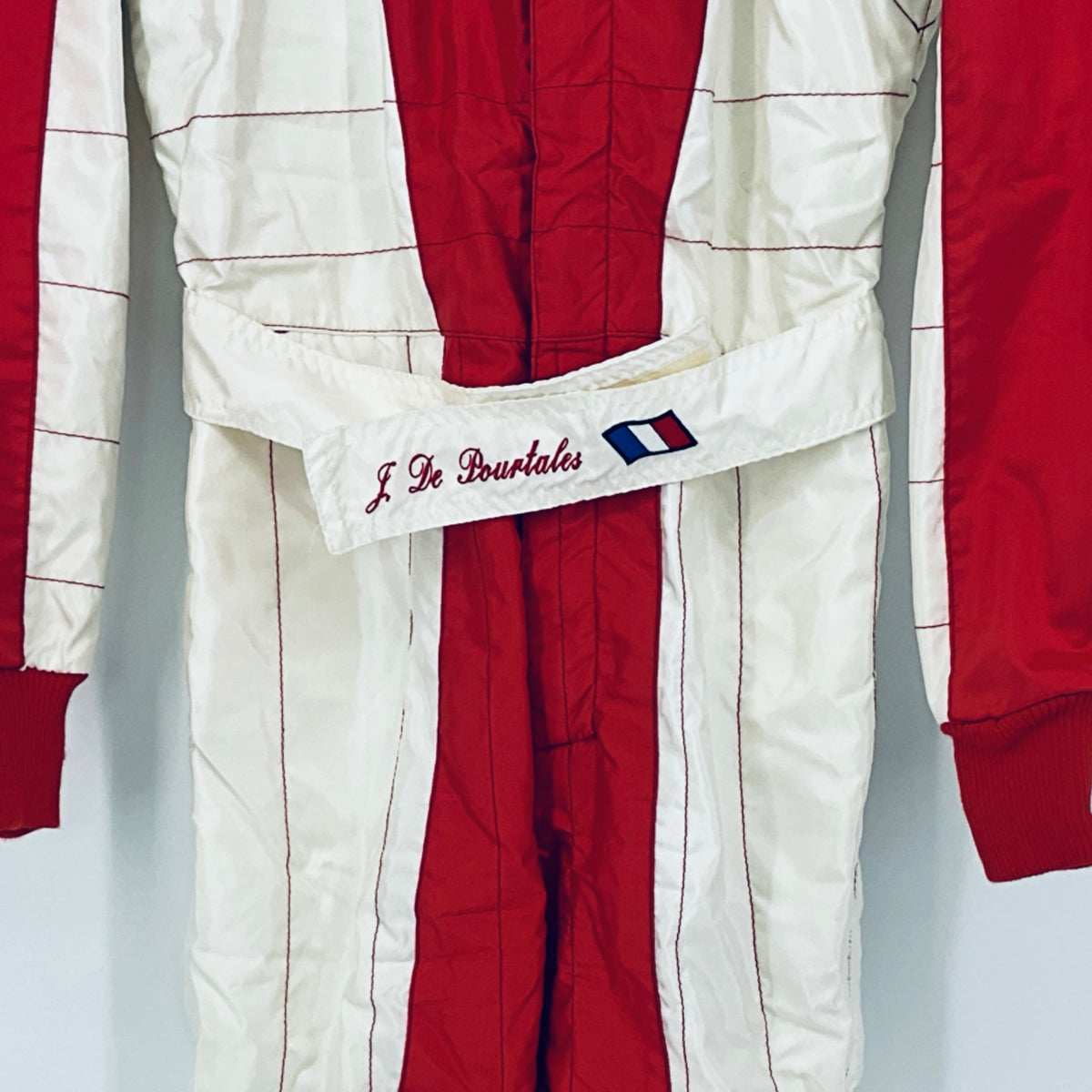 Red and white racing suit with embroidered Jean de Pourtalès name and flag