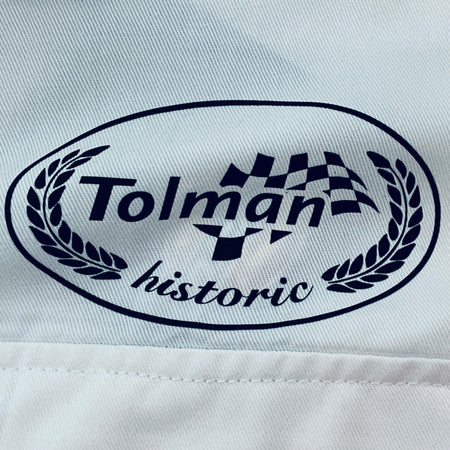 Embroidered Tolman historic logo on white overalls fabric