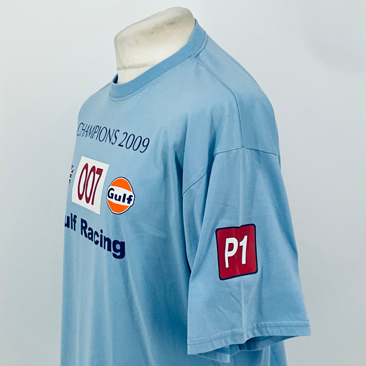 Light blue T-shirt sleeve and chest print with red 'P1' patch