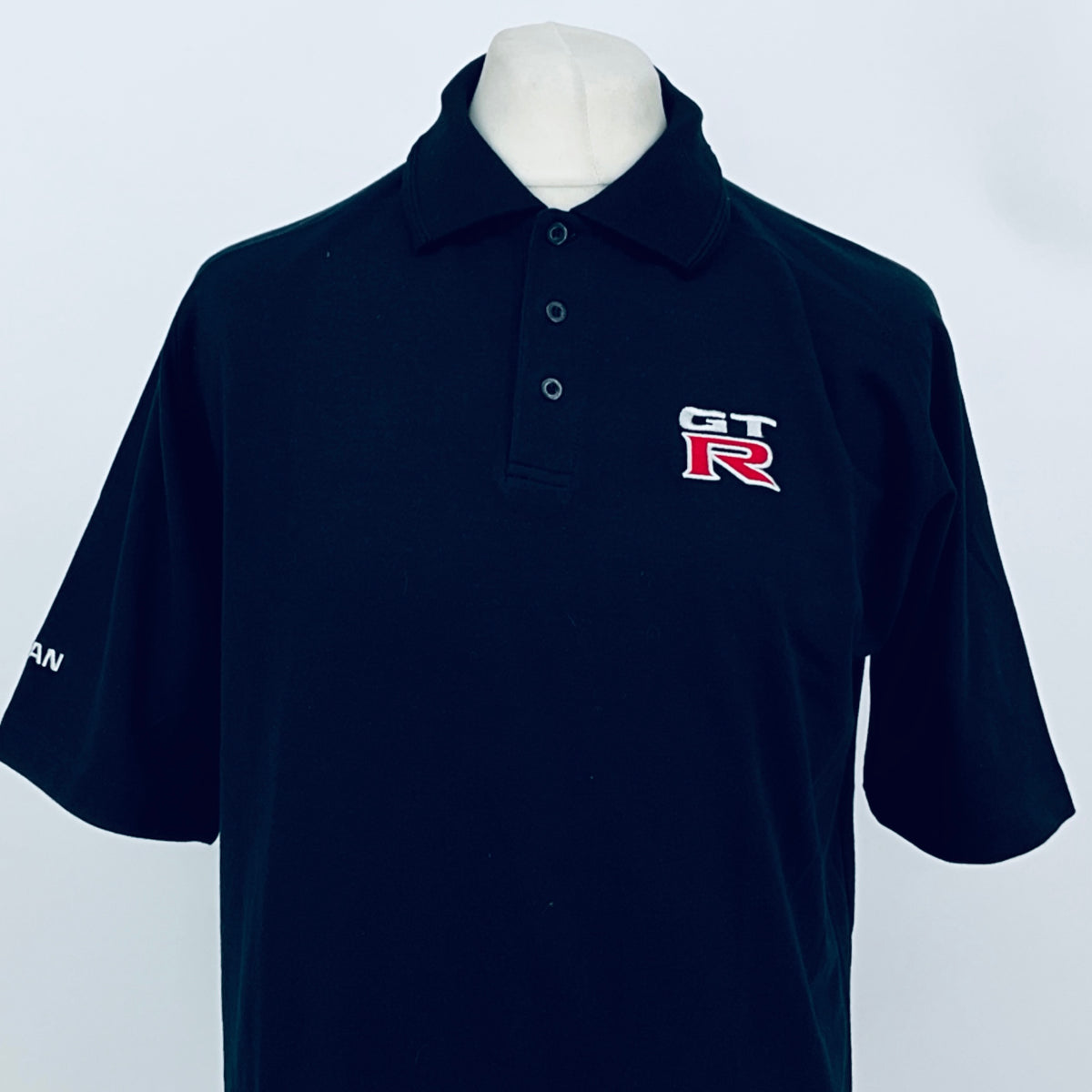 Black polo shirt with GT-R logo on chest, button-up collar, short sleeves