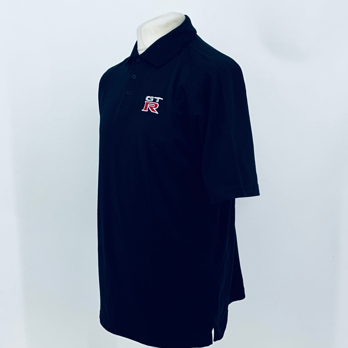 Black polo shirt side view with GT-R chest logo and buttoned collar, short sleeves