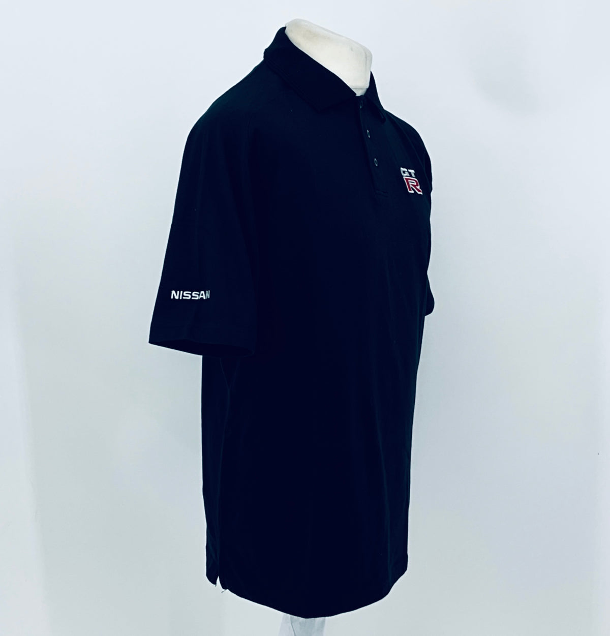 Black polo shirt with GT-R chest emblem, button collar, Nissan logo on sleeve