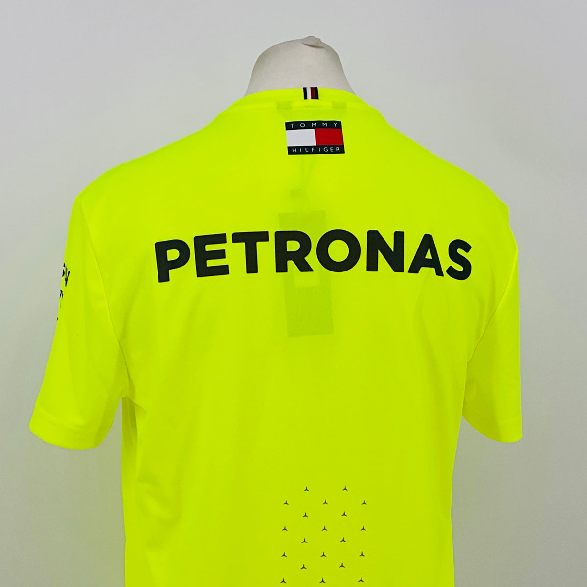 Neon yellow hi-vis T-shirt back close-up with large PETRONAS text and Tommy Hilfiger collar tag