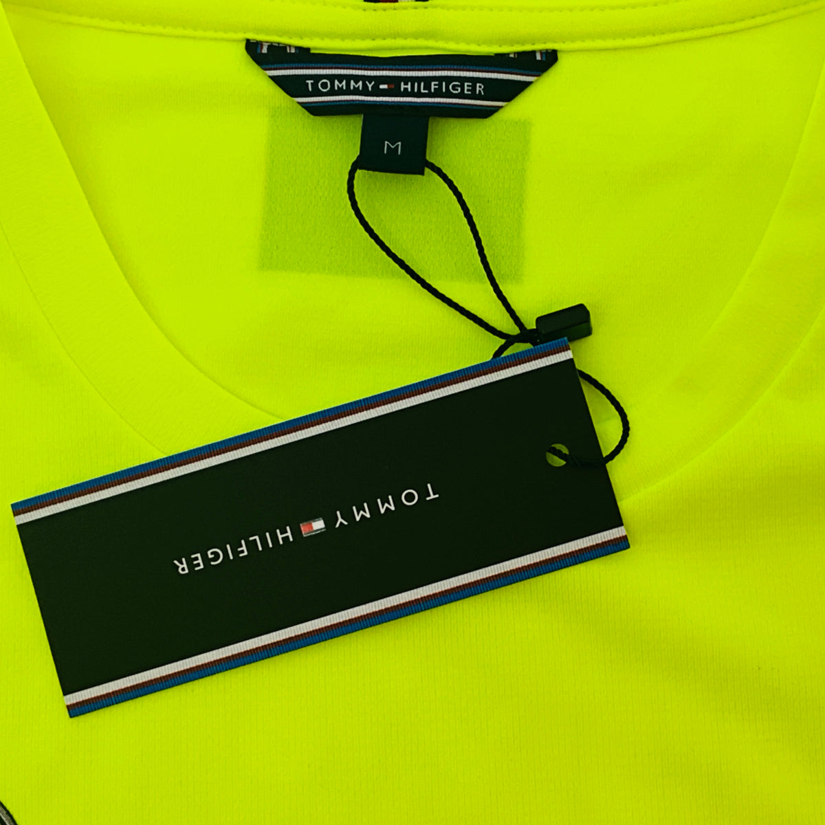 Hi-vis neon yellow T-shirt collar with Tommy Hilfiger tag and size label
