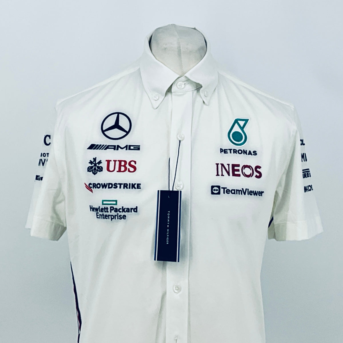 White short-sleeve button shirt with Petronas, INEOS, TeamViewer logos and hanging price tag