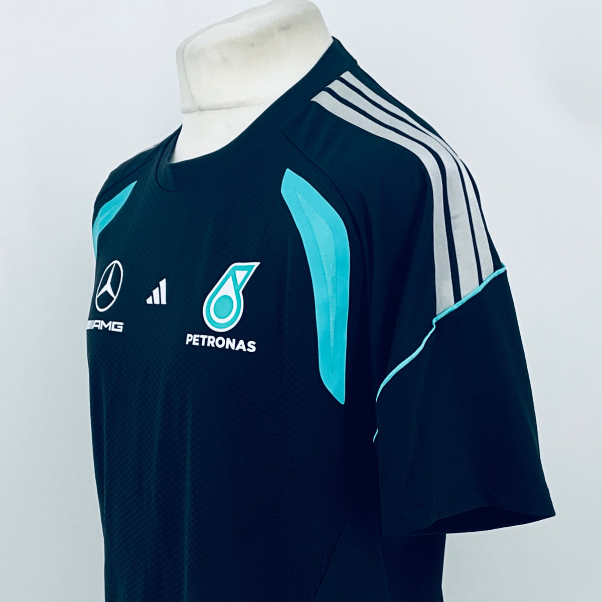 Navy F1 team t-shirt with white shoulder stripes and teal side swoosh graphic.