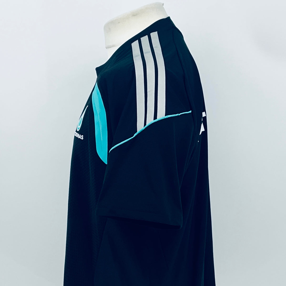 Navy F1 team t-shirt with white sleeve stripes and teal accent on the shoulder.