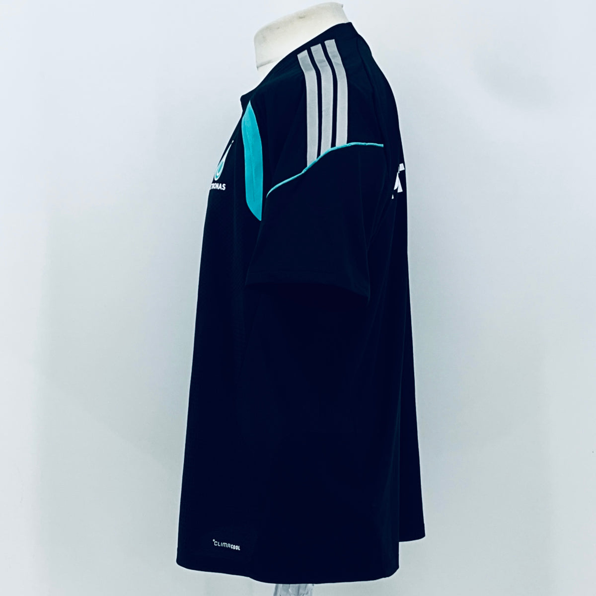 Navy F1 team t-shirt side view with white stripes and teal piping detail.