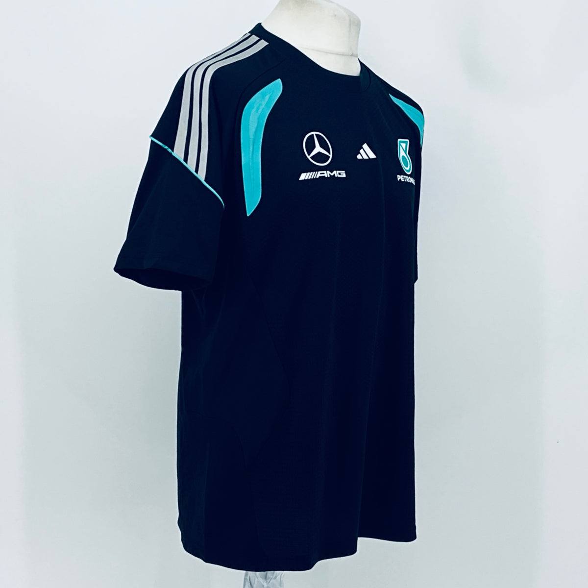 Navy F1 team t-shirt with white shoulder stripes and teal flame-style graphic.